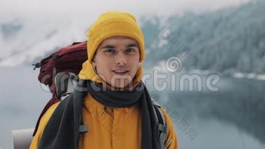 穿着<strong>冬装</strong>的年轻迷人男子的肖像。 穿着黄色<strong>冬装</strong>的徒步旅行者看着摄像机